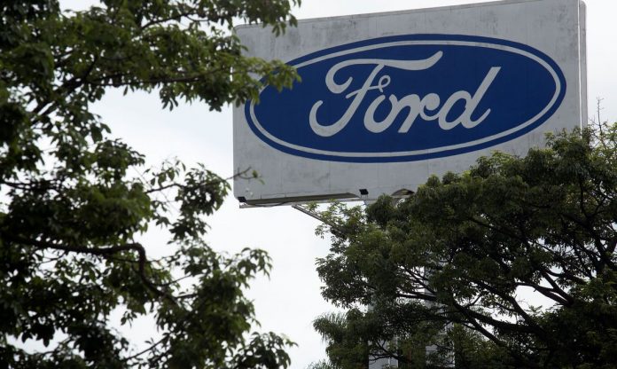 #Pracegover Foto: na imagem há árvores e uma placa da Ford