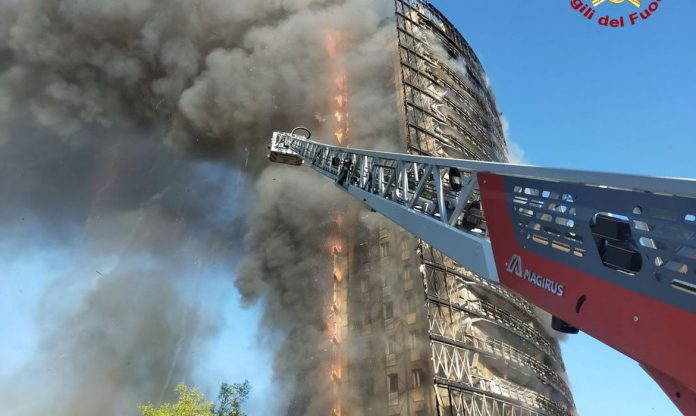 #Pracegover foto: na imagem há um prédio, fumaça e uma estrutura metálica