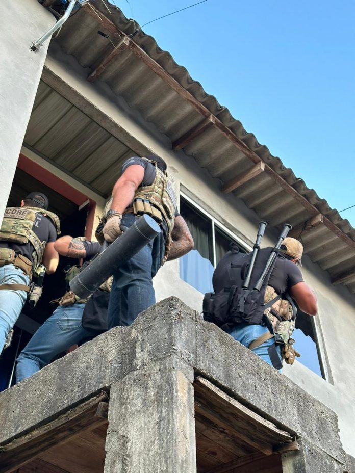Grupo de policiais civis, armados, entra em apartamento da mulher que foi detida identificada como criminosa que aplicava golpes de falso sequestro.