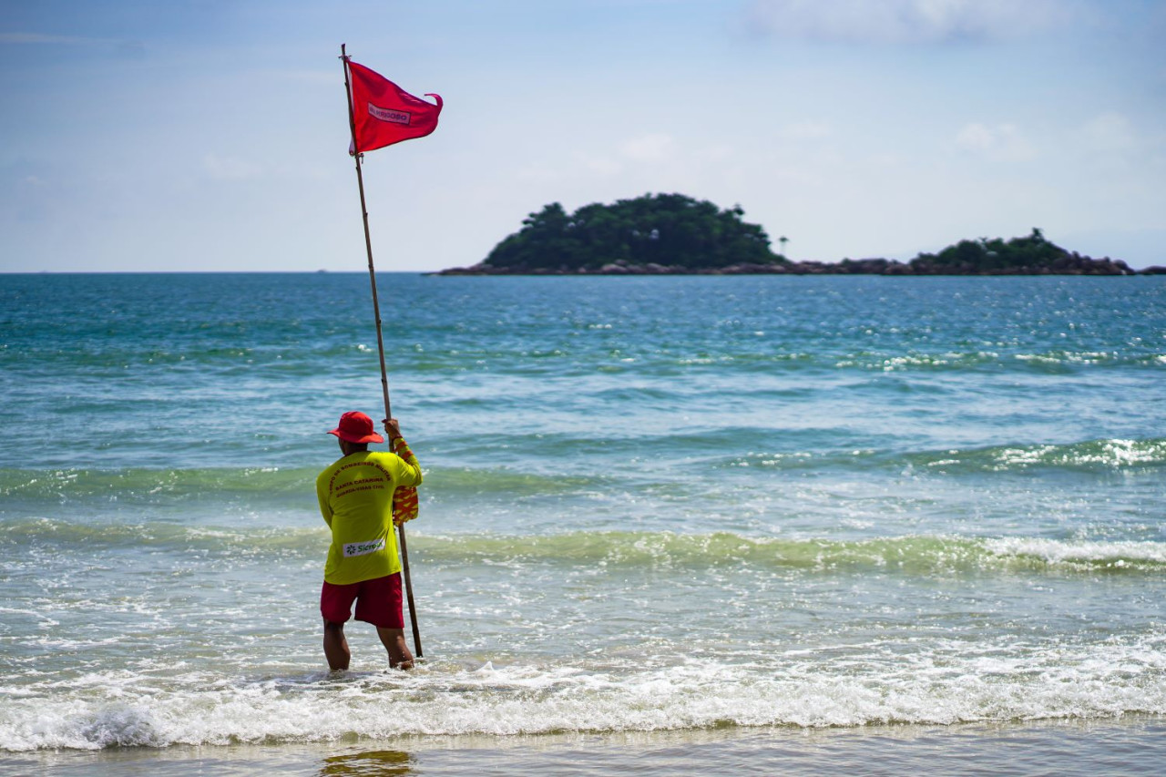 Bombeiro Militar fixa bandeira vermelha em areias de praia catarinense